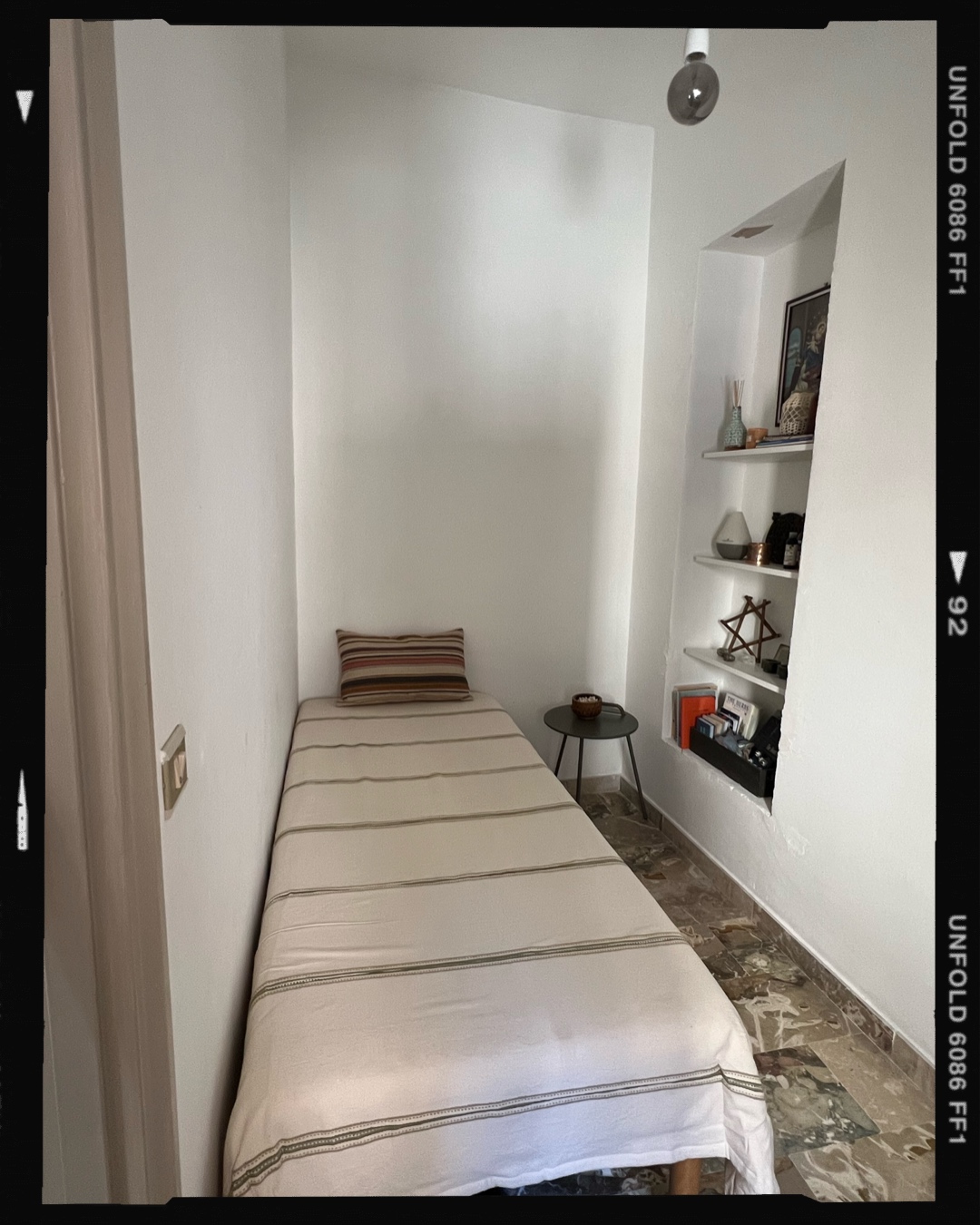 Half bedroom with single bed and alcove shelving
